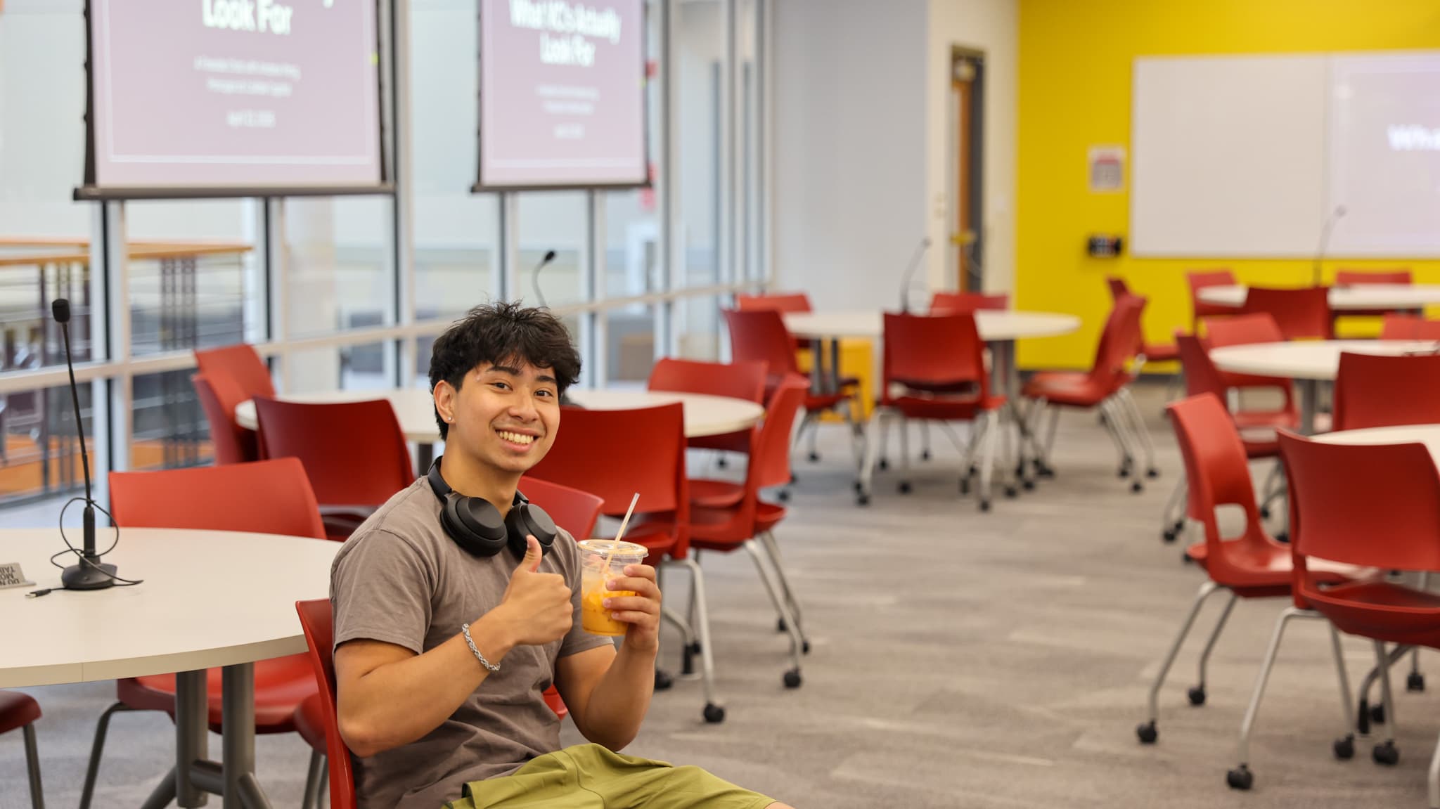 A DVCG member smiling in a session room, holding a smoothie